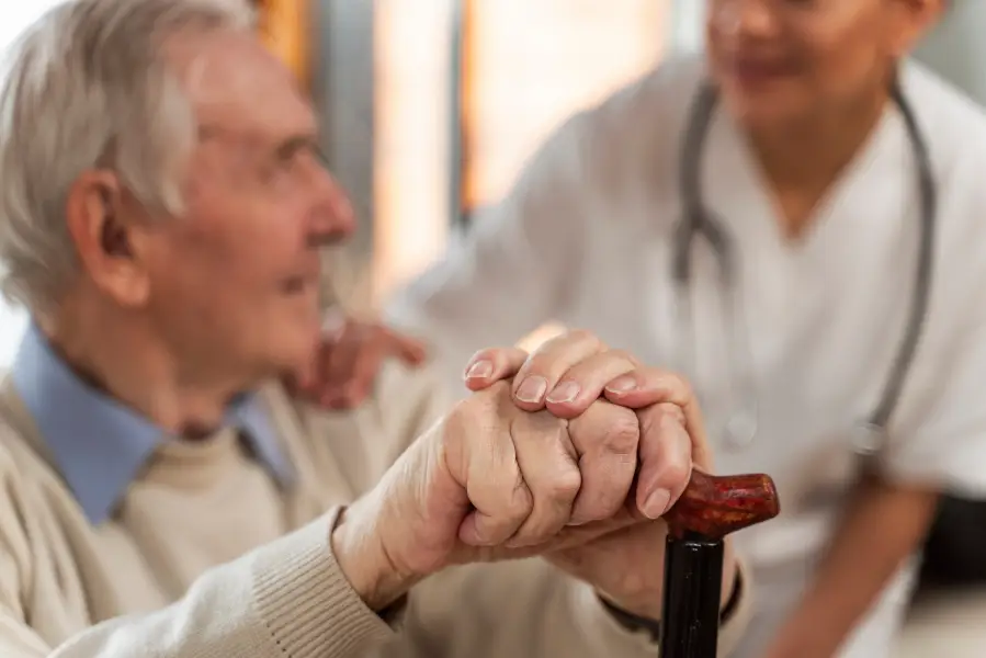 Casual senior man at home with doctor